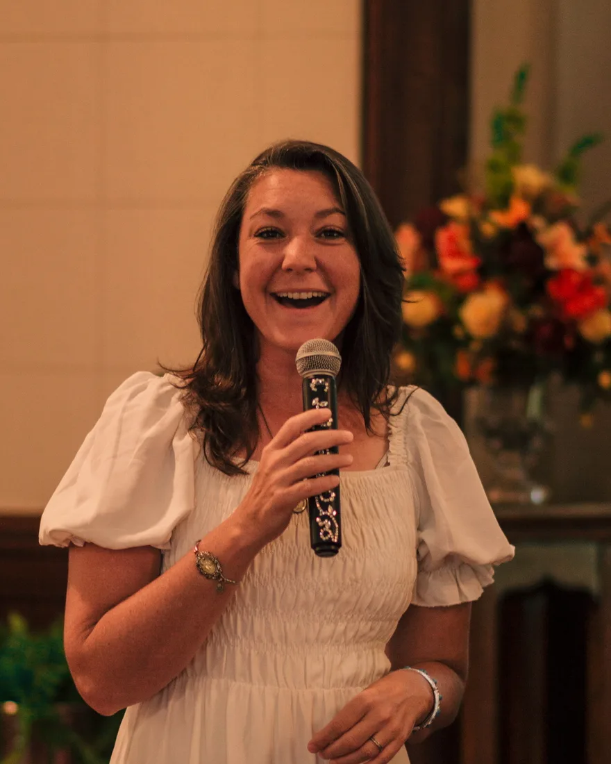 Erin Watson, Mama E, singing with a microphone in the sanctuary